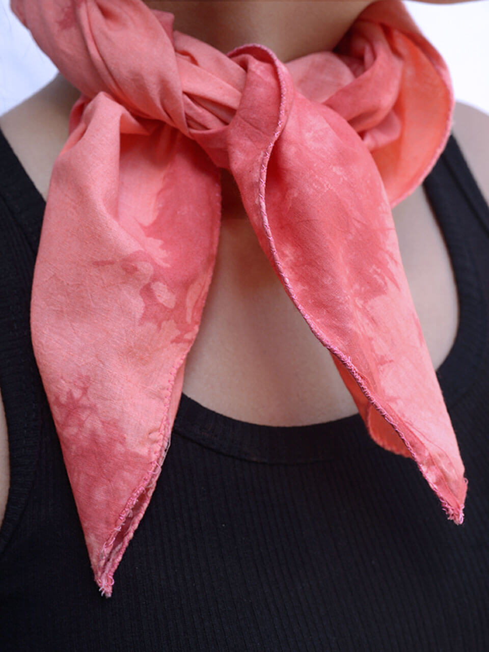A woman elegantly dressed, featuring a pink scarf and a striking red tie, exuding confidence and style.