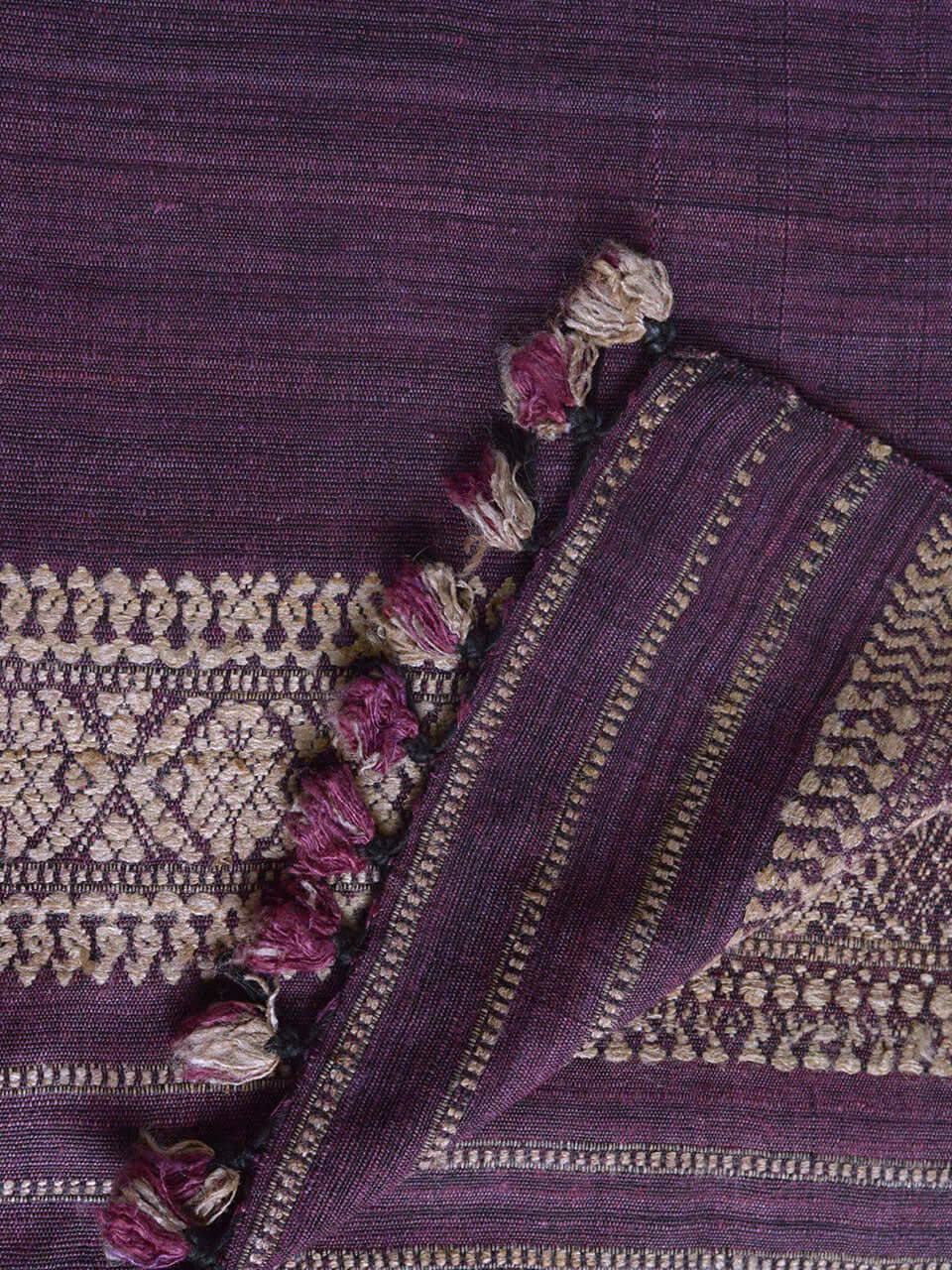 A close-up view of luxurious purple and gold fabric, showcasing intricate textures and vibrant colors