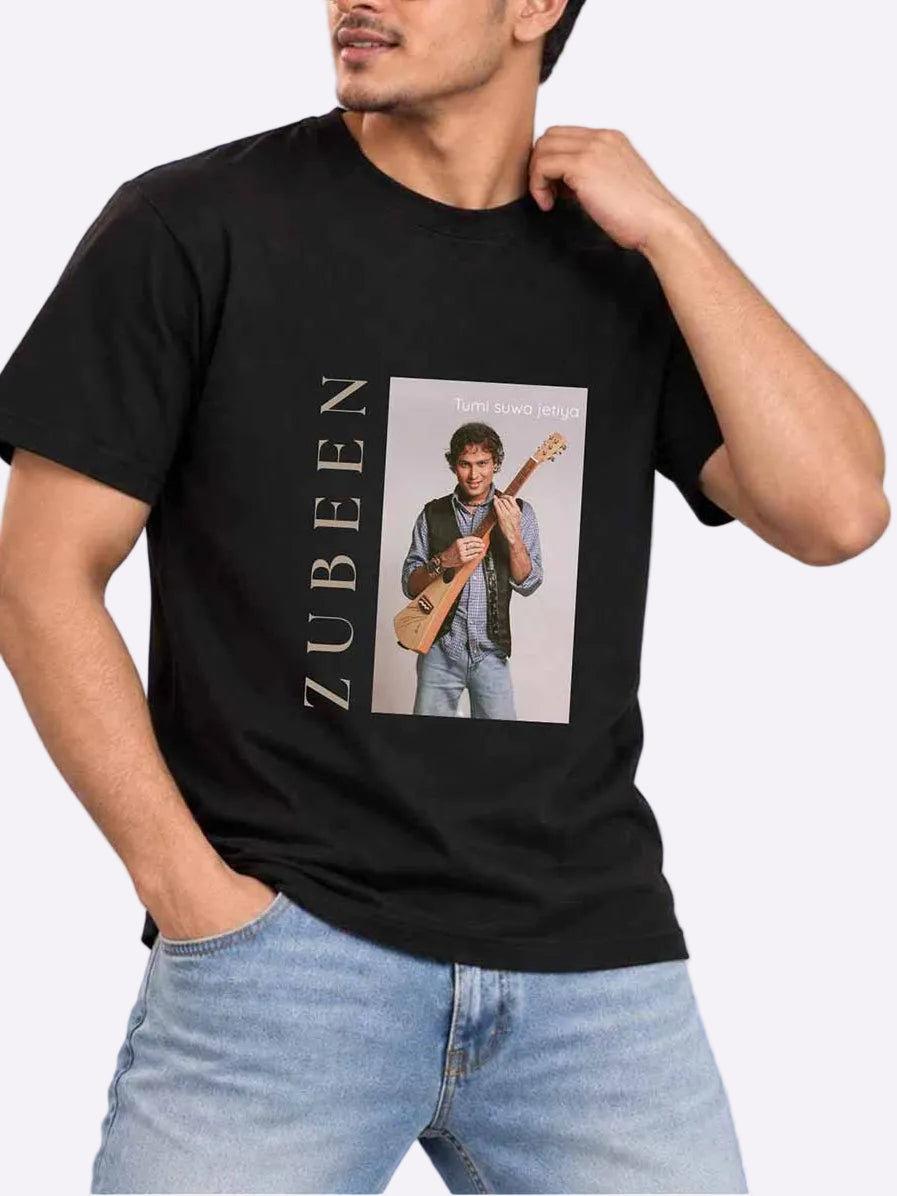 A man wearing a black graphic t-shirt with a photo print of Zubeen and the name &