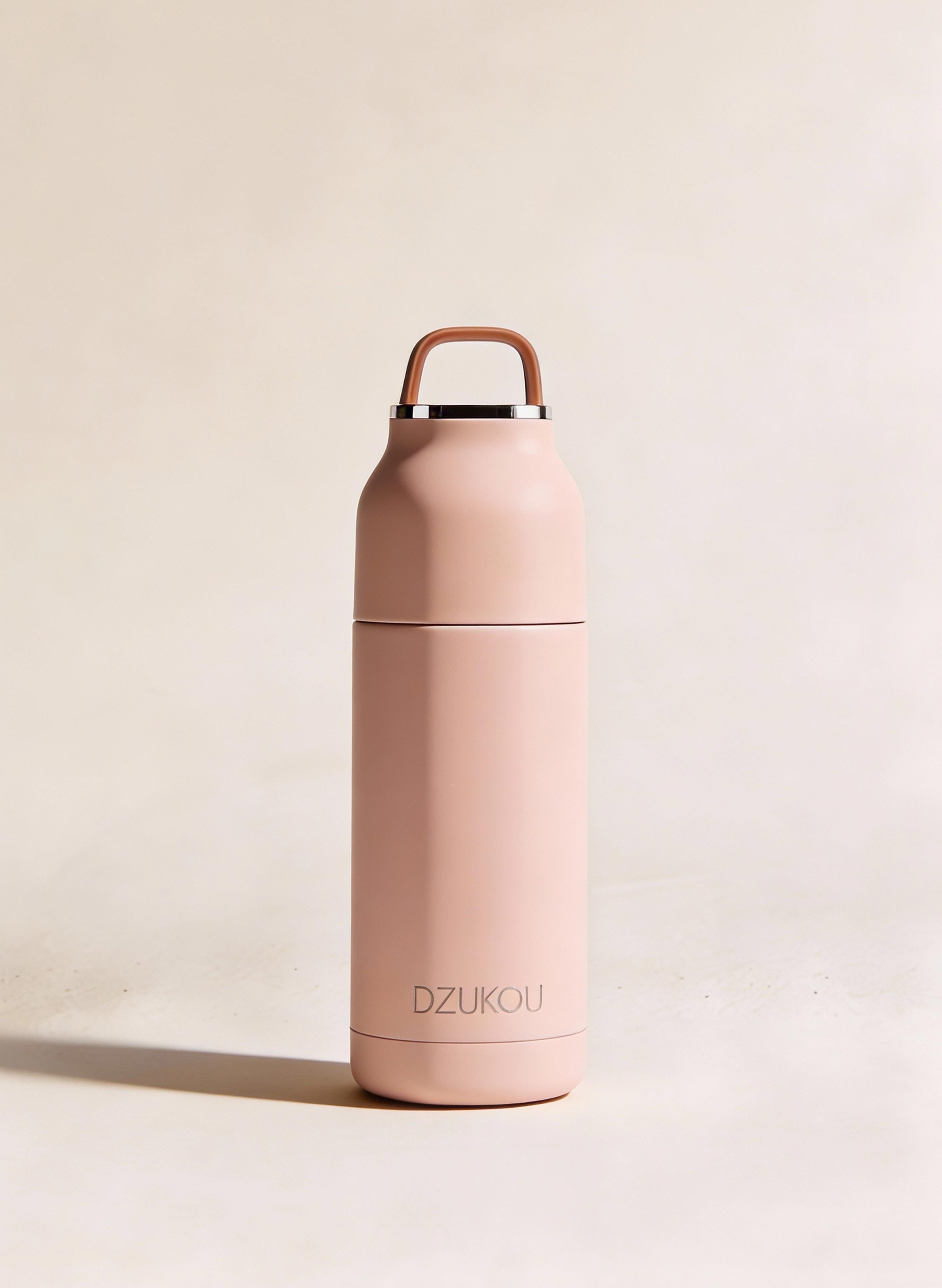 Pink insulated bottle with handle on a beige background
