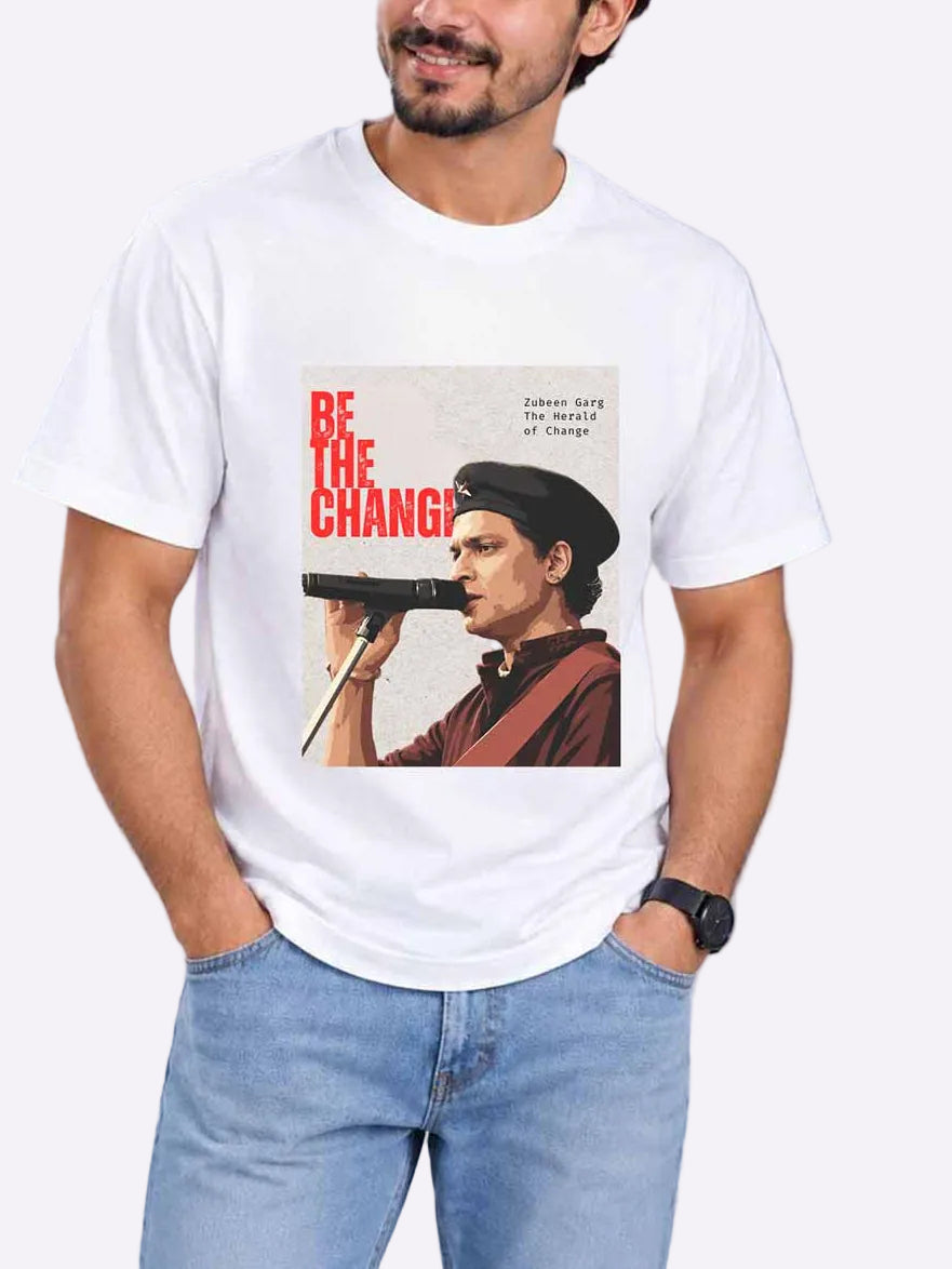 A man wearing a white graphic t-shirt with a vintage-style print of a man holding a gun and the text &