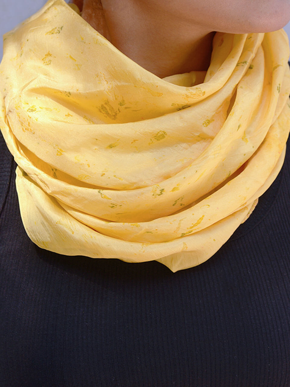 A woman elegantly draped in a vibrant yellow scarf, showcasing a blend of style and warmth