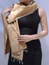 A woman in a black dress elegantly draped with a tan scarf, exuding sophistication and style