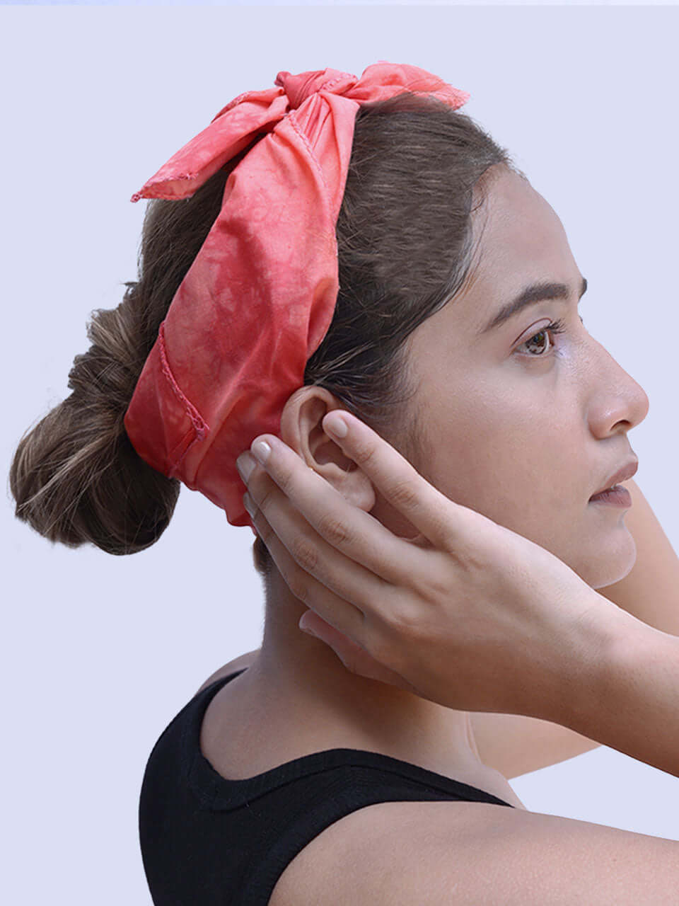 A woman with a pink headband, smiling and looking confidently at the camera, showcasing her vibrant style.