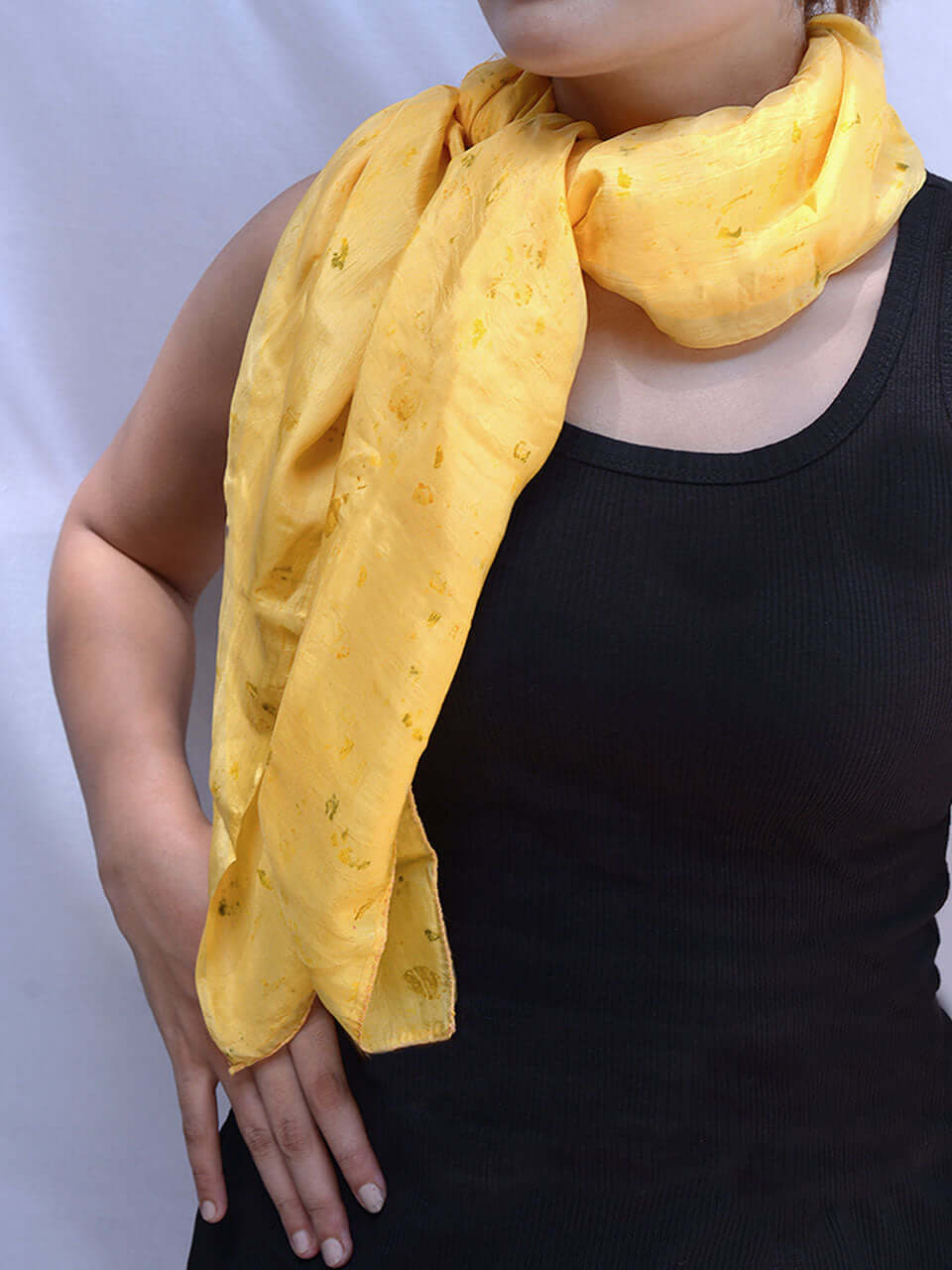 A woman elegantly draped in a vibrant yellow scarf, exuding warmth and style