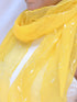 A woman elegantly draped in a vibrant yellow scarf, exuding warmth and style.