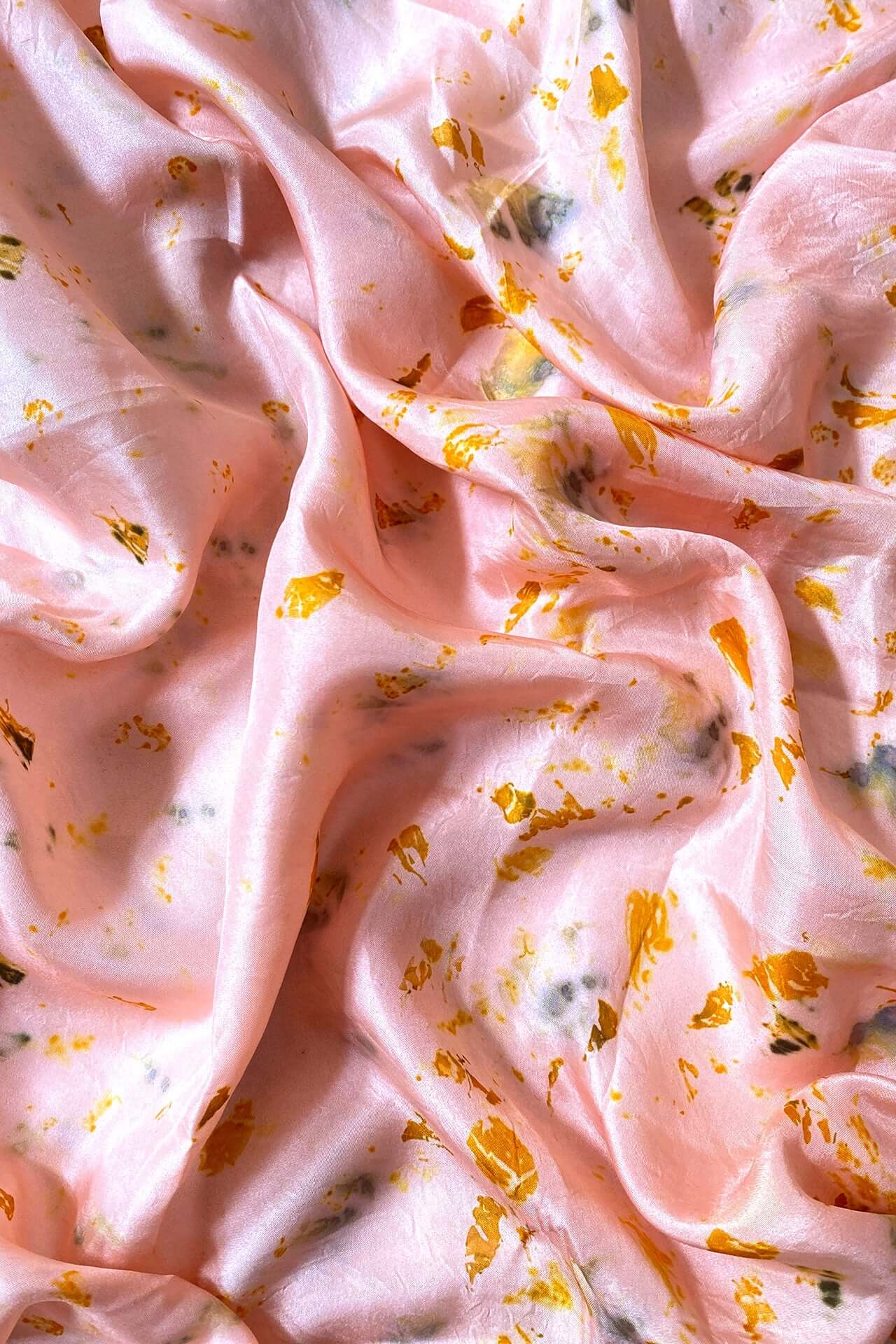 A luxurious pink silk fabric adorned with intricate gold leaf patterns, showcasing elegance and sophistication