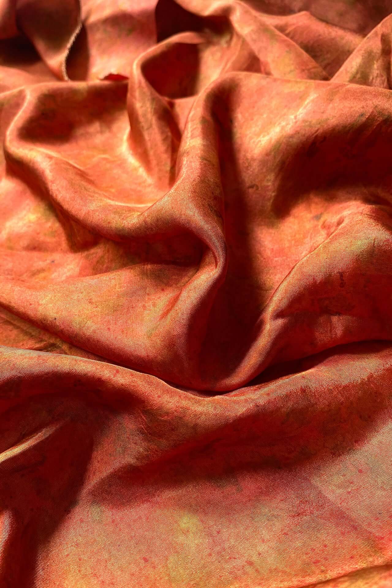 A close-up of a woman wearing a pink cloth, showcasing her expression and the texture of the fabric