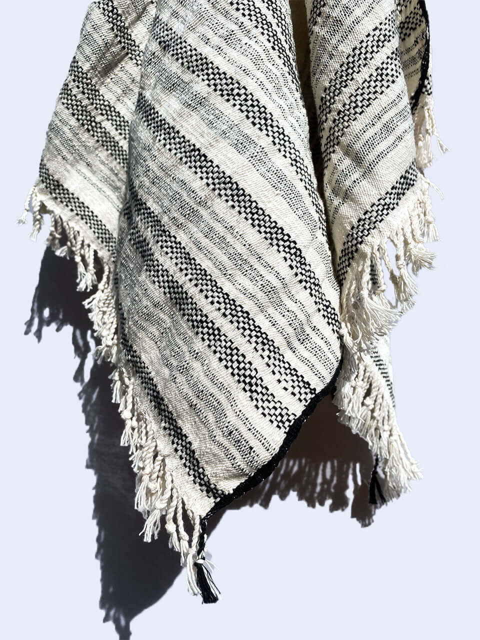 A black and white striped organic cotton hand towel elegantly displayed on a wall.