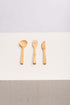 A set of three wooden spoons and forks arranged neatly on a light background