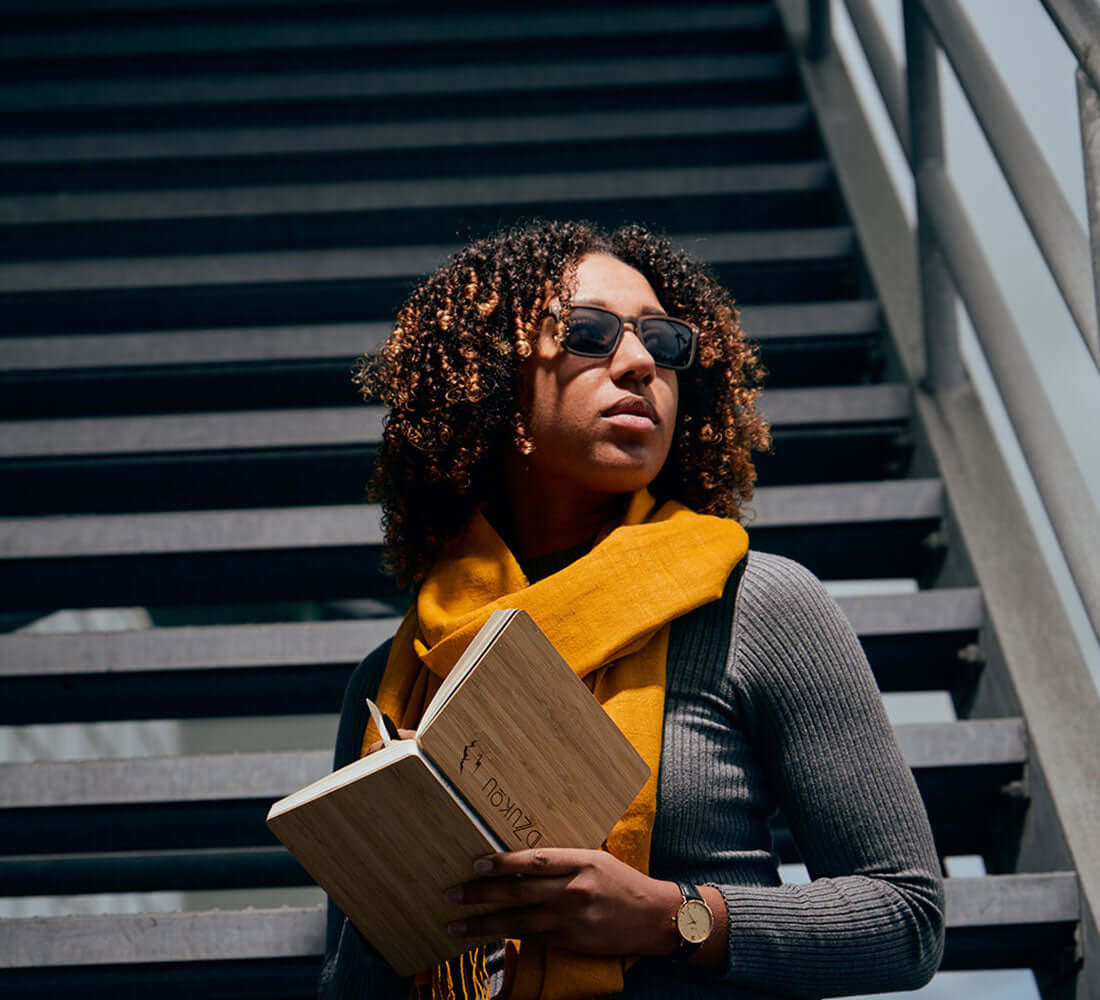 girl wrapping a mustard colour stole holding a notebook