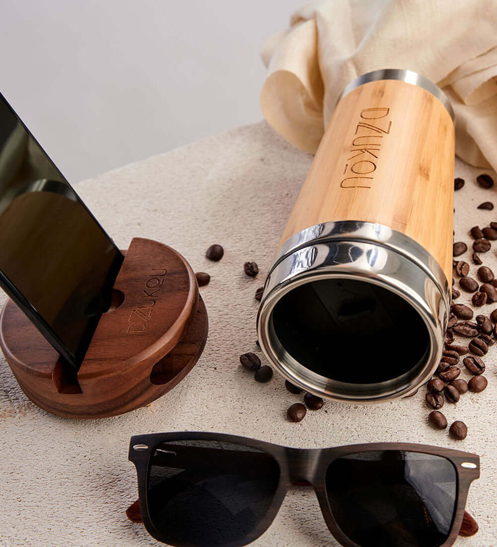 a pair of sunglasses and a mobile stand kept near a bottle