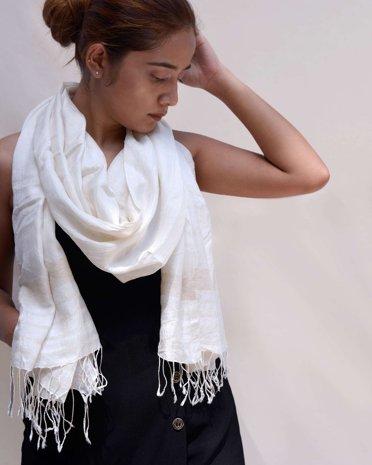 A woman in a black top adorned with a white scarf, exuding elegance and style
