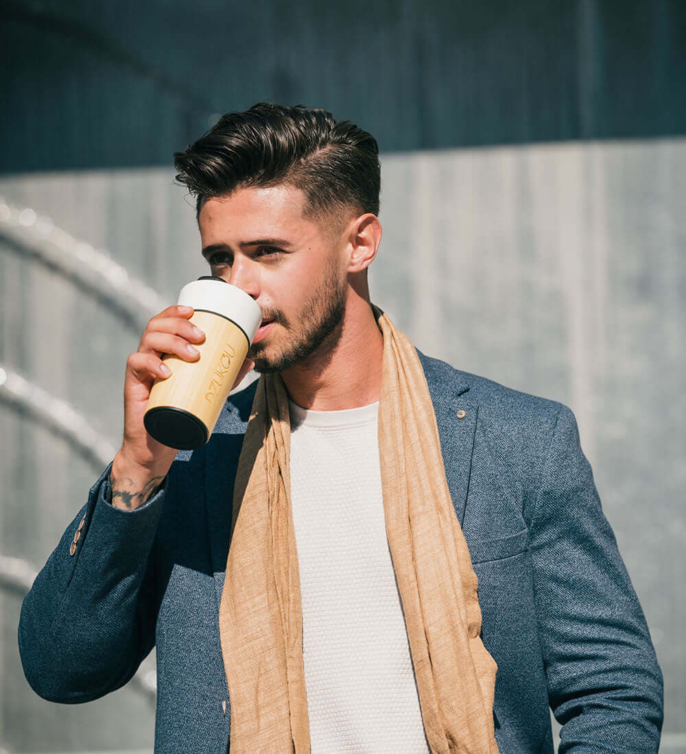 man wearing a stole drinking from eco friendly mug