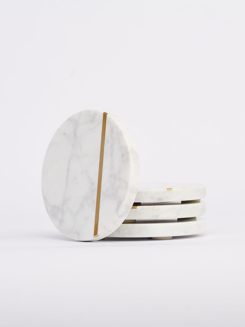 White marble coasters featuring elegant gold stripes, adding a touch of sophistication to any table setting.