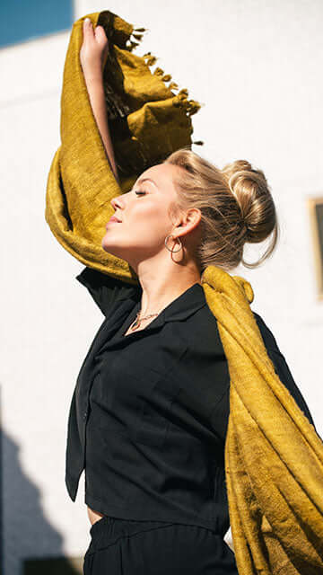 woman holding a mustard stole