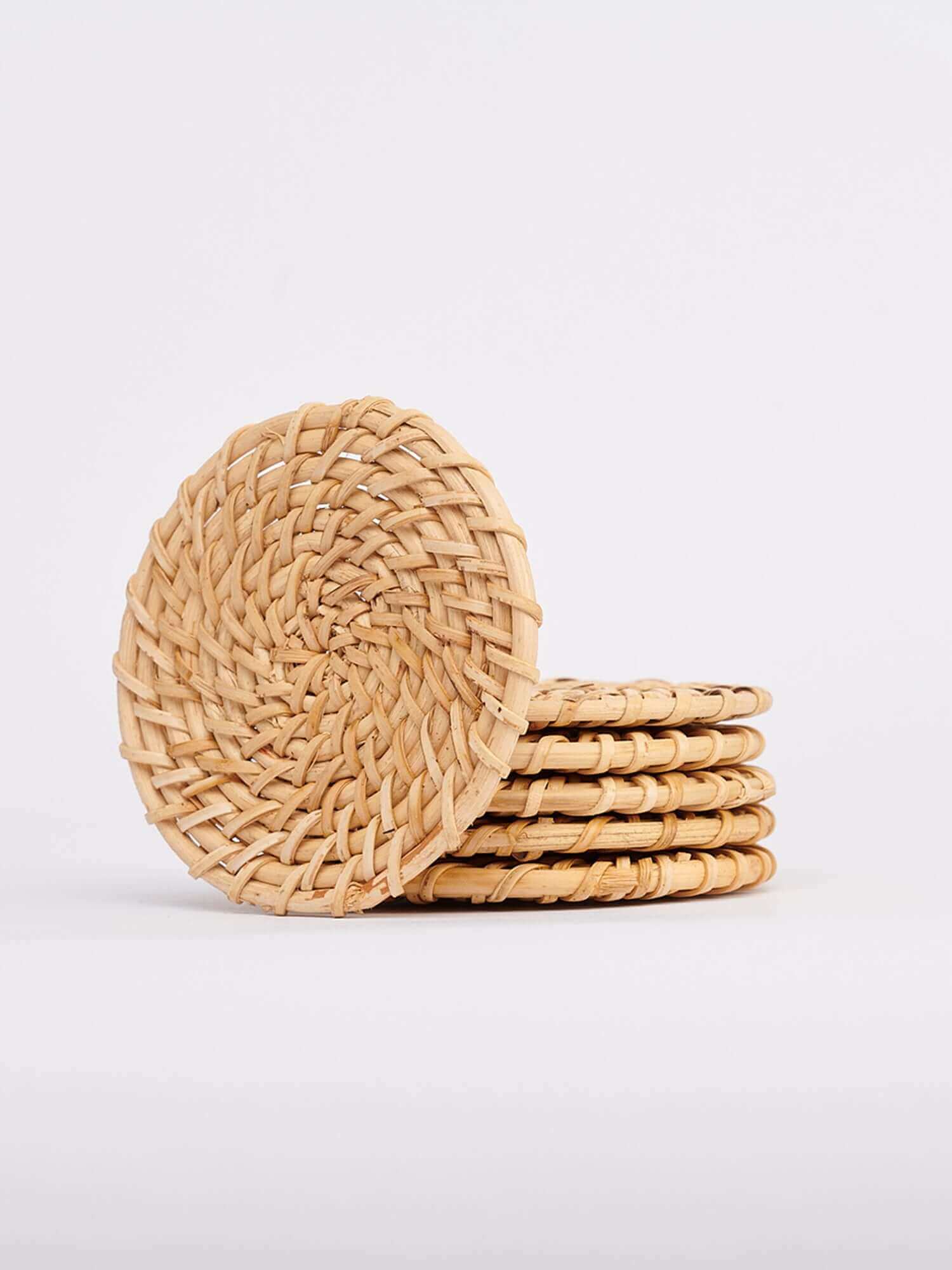 A stack of four cane coasters arranged neatly on a clean white background.