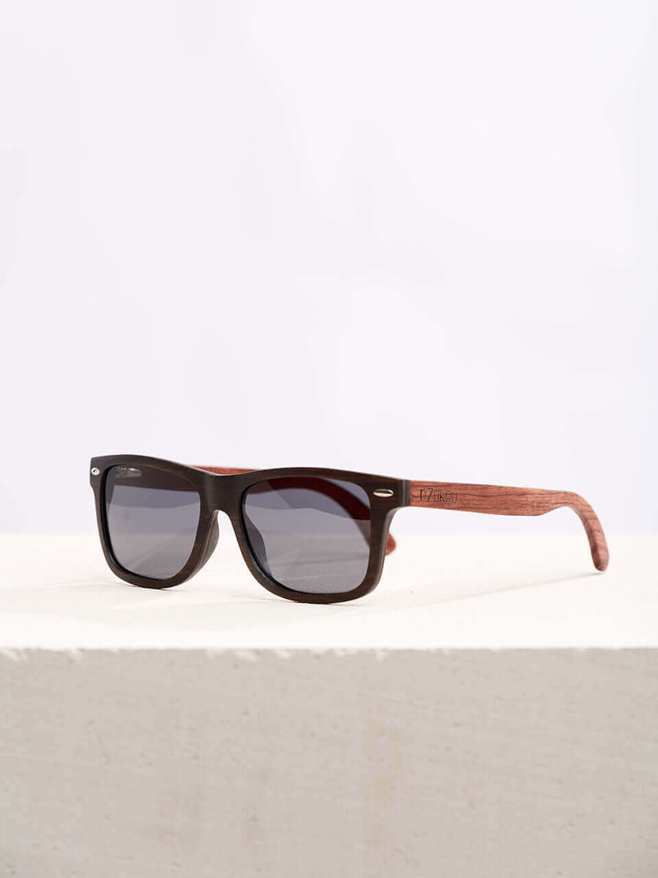 A wooden sunglasses featuring a stylish wooden frame in a clean surface with a neutral background, showcasing a unique and eco-friendly design.
