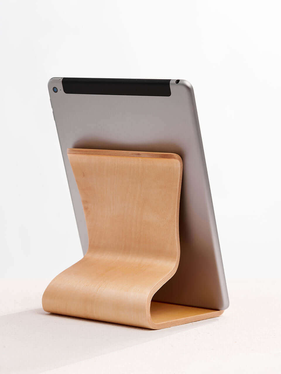 A back view of the tablet stand placed on a clean white surface, showcasing a blend of technology and natural materials.