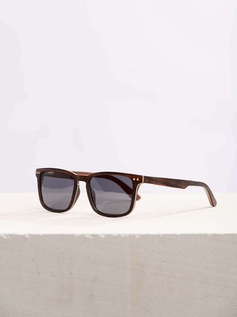 A wooden sunglasses featuring a stylish wooden frame in a clean surface with a neutral background, showcasing a unique and eco-friendly design.