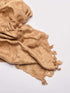 A beige Eri silk shawl spread out on a surface, highlighting its soft texture and natural color.