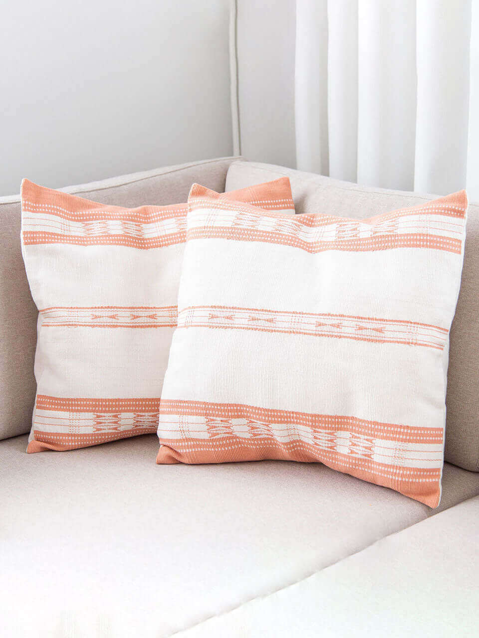 Two pillows featuring a vibrant pink and white striped pattern, arranged neatly for a decorative touch.