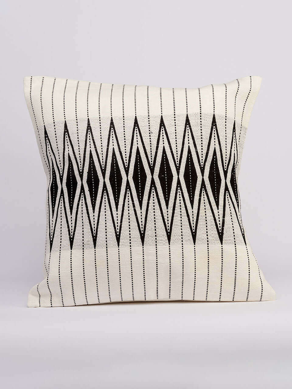 A white pillow cover featuring a black and white geometric pattern, adding a modern touch to any decor.