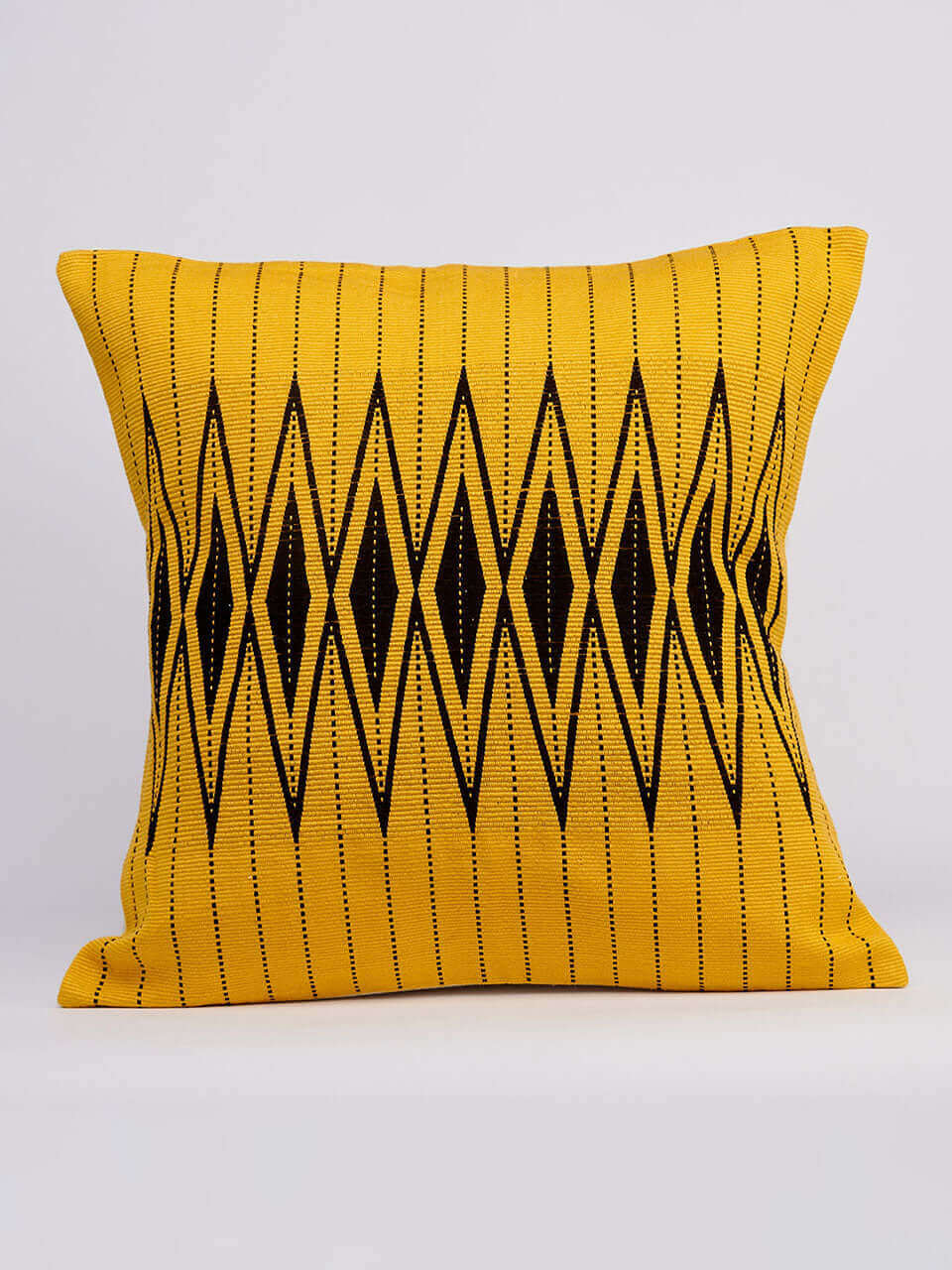 A yellow pillow cover featuring a black and white geometric pattern, adding a modern touch to any decor.
