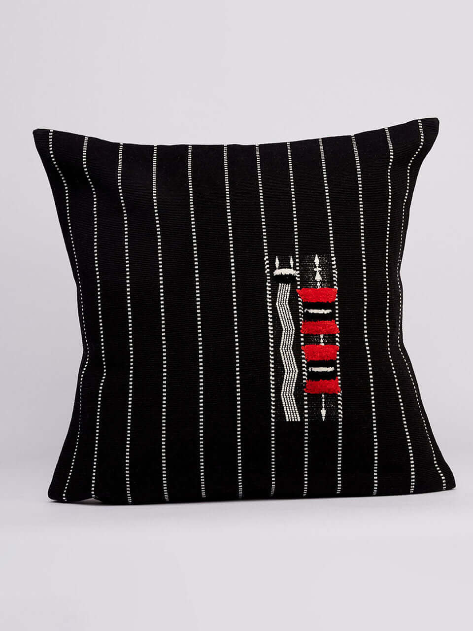 A black pillow cover featuring bold red and white stripes, on a neutral background.