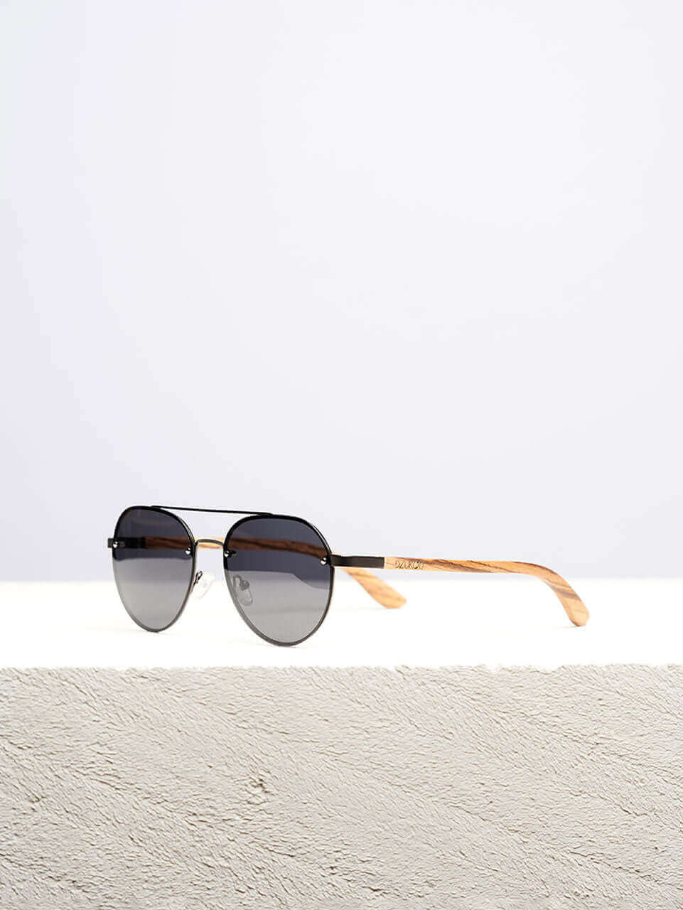 A wooden sunglasses featuring a stylish wooden frame in a clean surface with a neutral background, showcasing a unique and eco-friendly design.