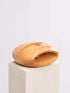A cell phone stand placed on a white block, showcasing a blend of technology and natural materials.
