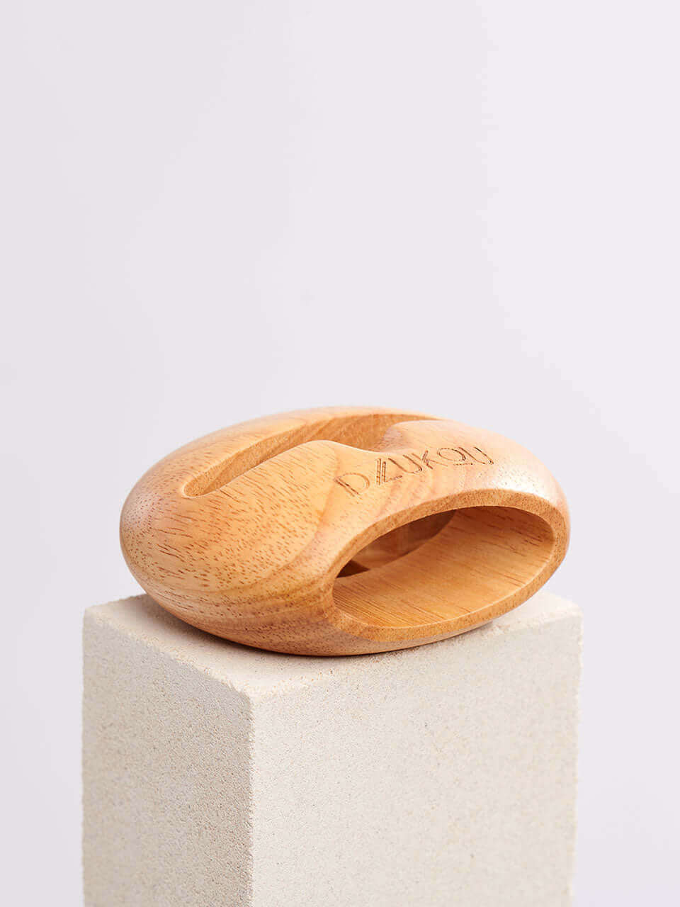 A cell phone stand placed on a white block, showcasing a blend of technology and natural materials.