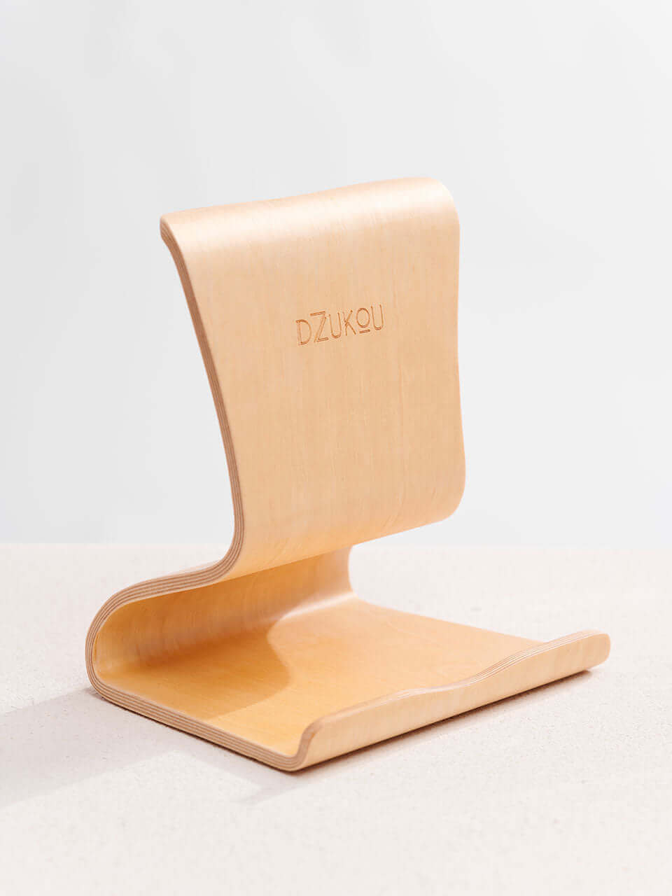 A tablet stand placed on a clean white surface, showcasing a blend of technology and natural materials.