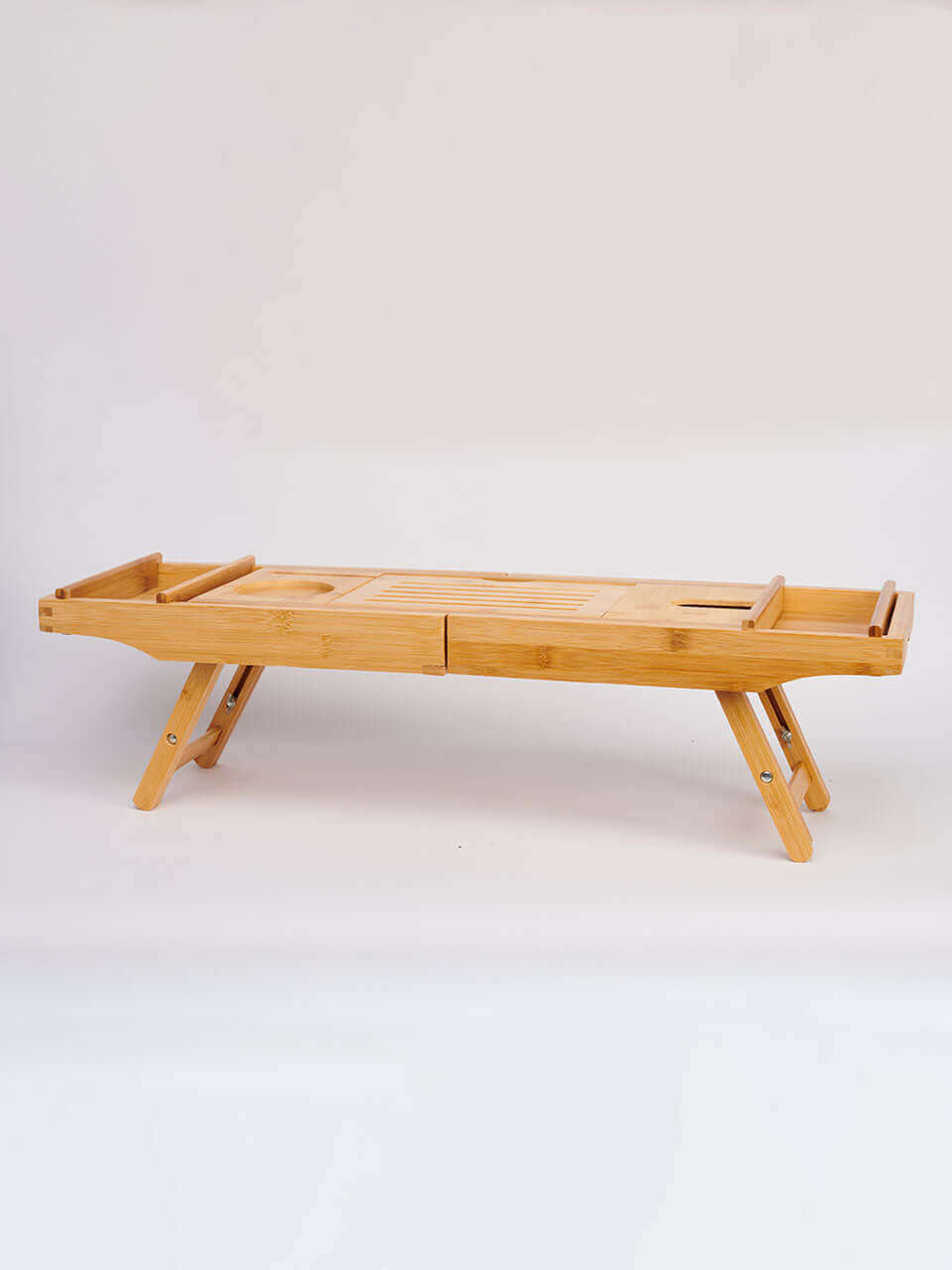 A wooden bath tub caddy featuring a bench design with two legs and a wooden tray for holding items.