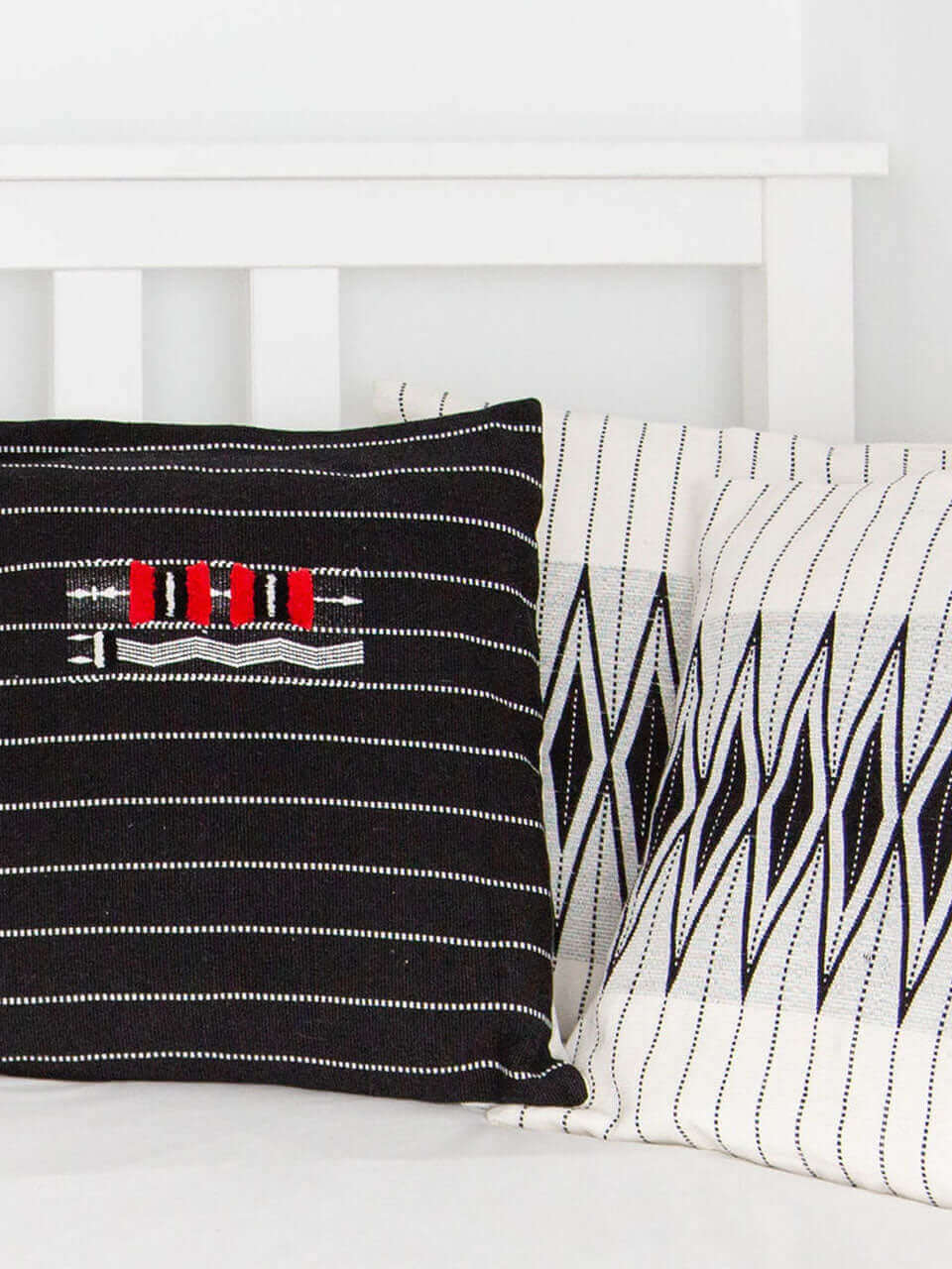 Two pillow featuring bold red and black stripes, arranged neatly on a soft surface.