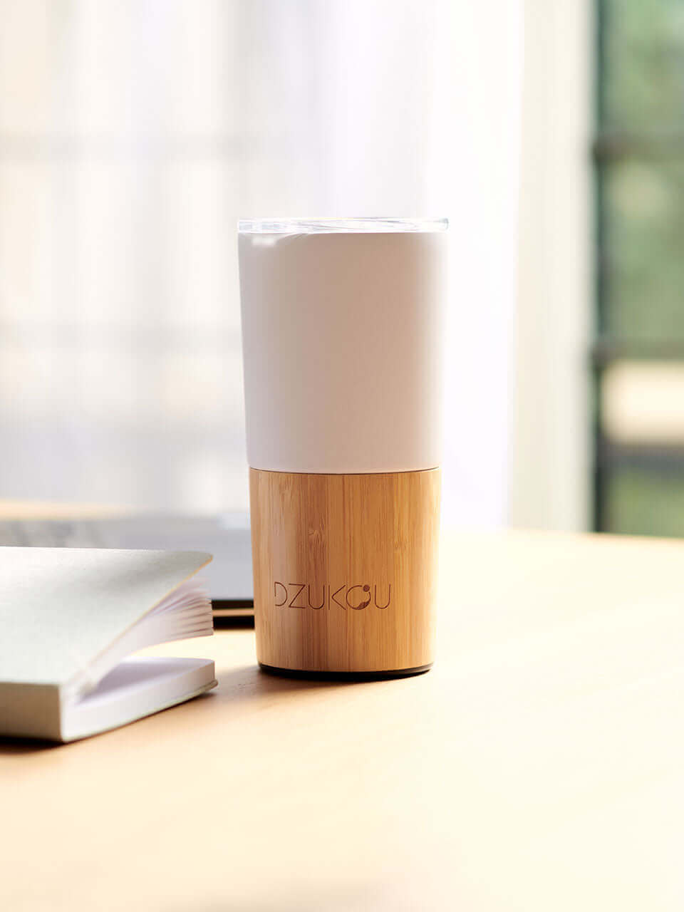 A white and bamboo coffee tumbler in a white background, showcasing a blend of natural materials.