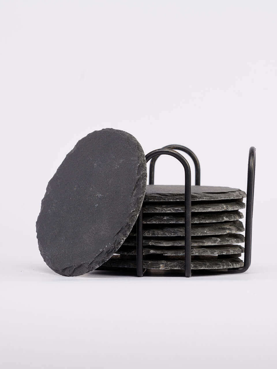 A stack of black slate coasters neatly arranged on a sleek metal stand, showcasing a modern and elegant design.