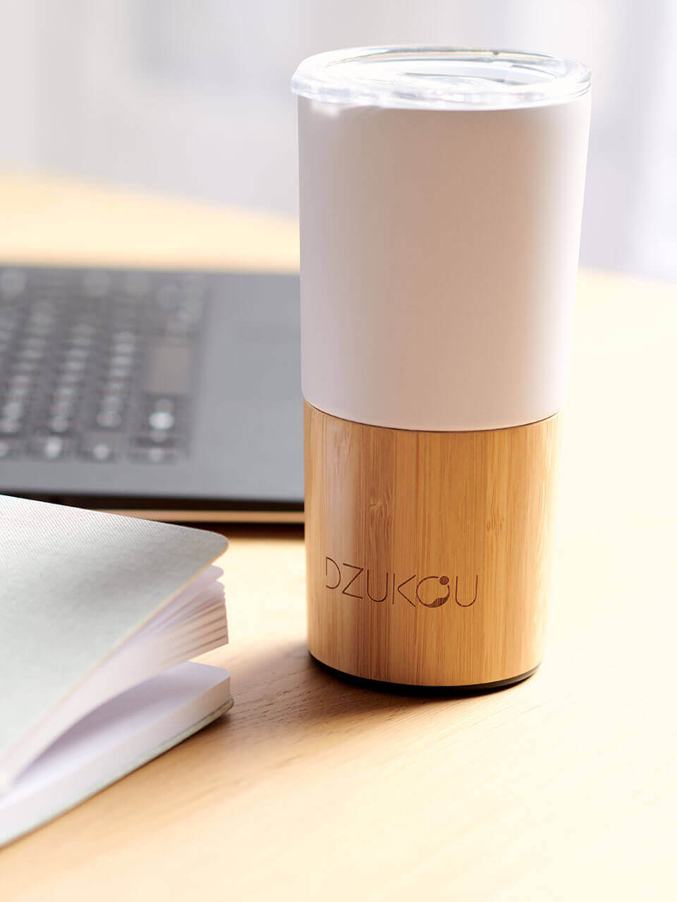 A white and bamboo coffee tumbler in a white background, showcasing a blend of natural materials.