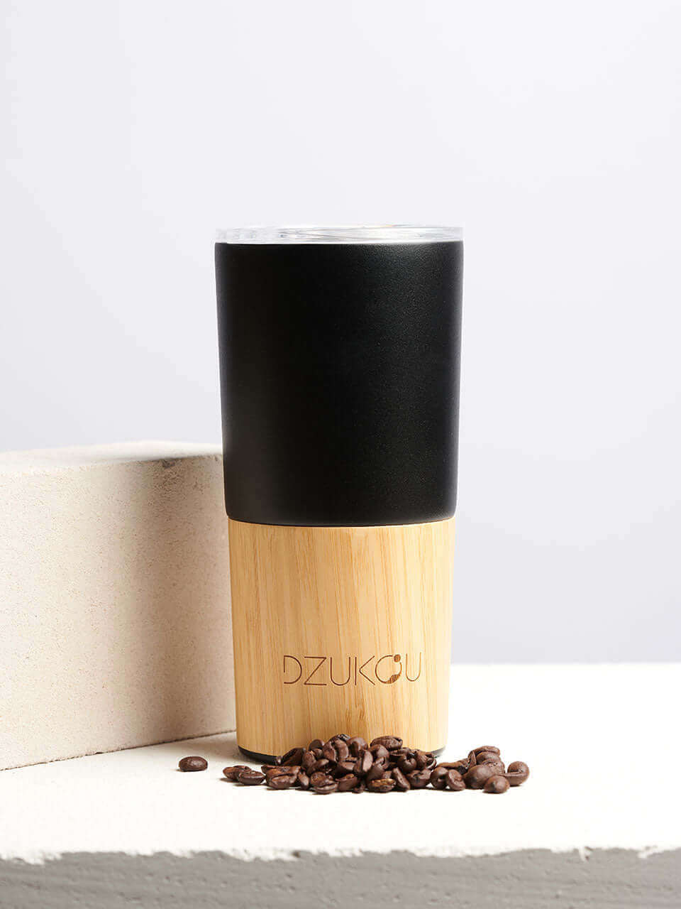 A black and bamboo coffee tumbler in a white background, showcasing a blend of natural materials.