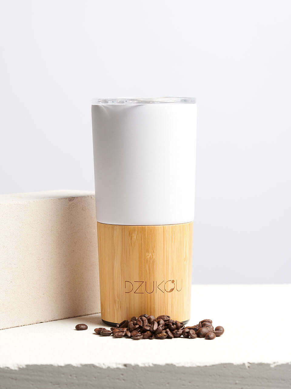 A white and bamboo coffee tumbler in a white background, showcasing a blend of natural materials.