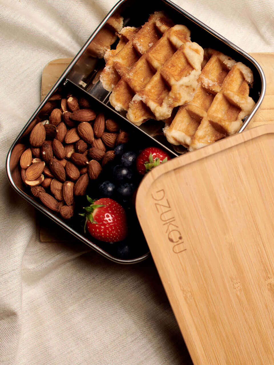 A bamboo lunch box containing delicious waffles topped with fresh berries.