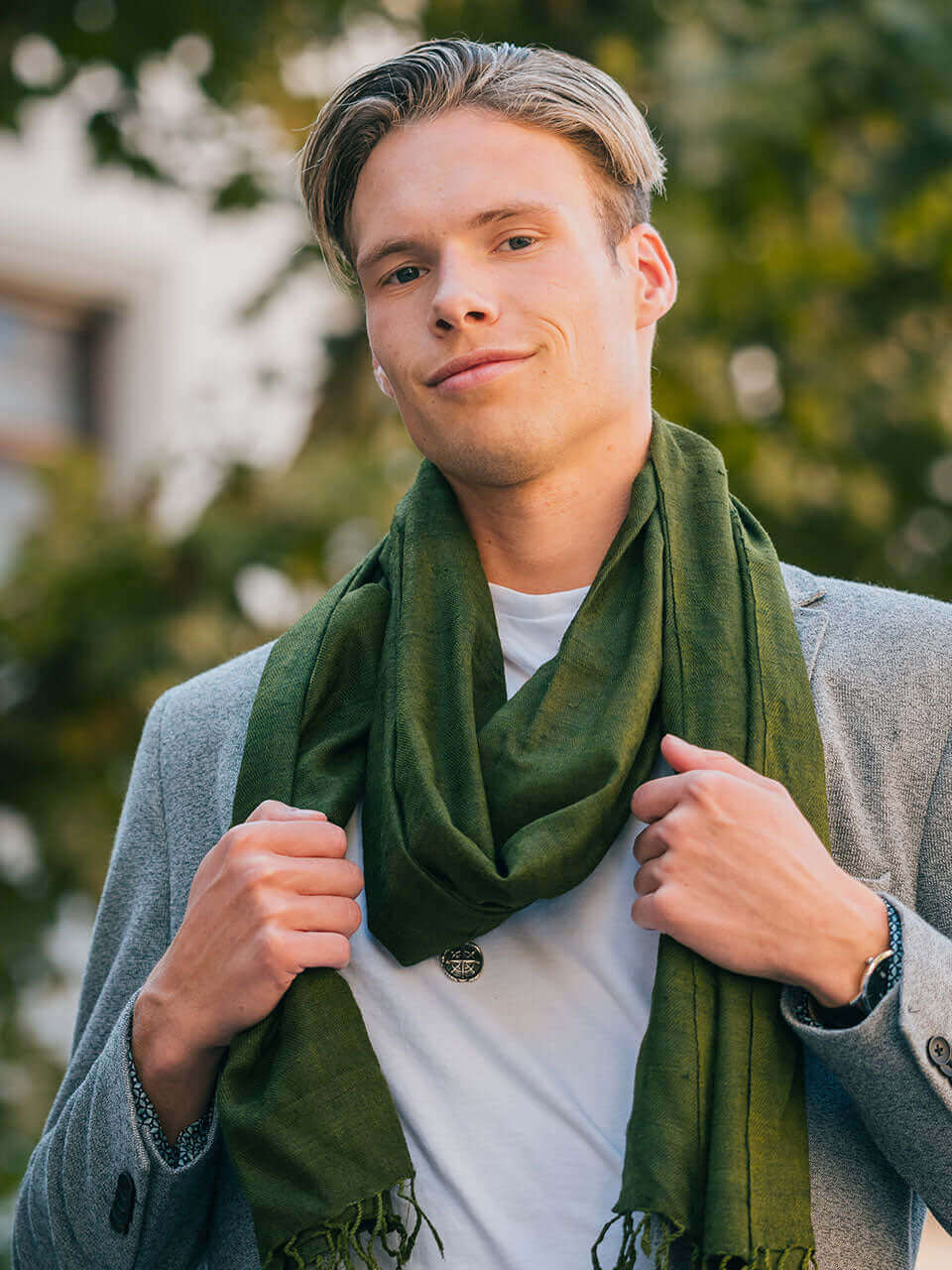 A man wearing a suit and a green scarf, exuding professionalism and style.