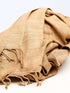 A beige stole resting on a clean white surface, showcasing texture and color contrast.