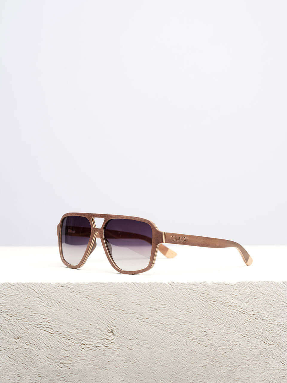 A wooden sunglasses featuring a stylish wooden frame in a clean surface with a neutral background, showcasing a unique and eco-friendly design.
