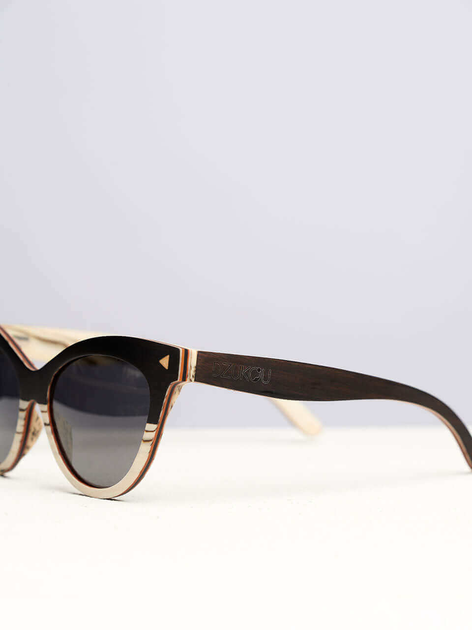 A wooden cat eye sunglass featuring a side view of the stylish wooden frame in a clean surface with a neutral background, showcasing a unique and eco-friendly design.