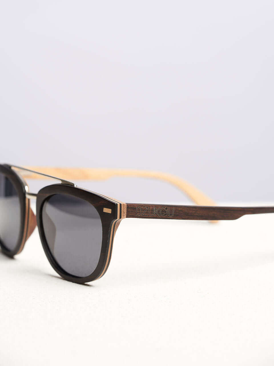 A wooden sunglasses featuring a side view of the stylish wooden frame in a clean surface with a neutral background, showcasing a unique and eco-friendly design.