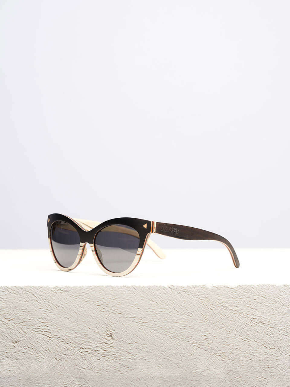 A wooden cat eye sunglass featuring a stylish wooden frame in a clean surface with a neutral background, showcasing a unique and eco-friendly design.