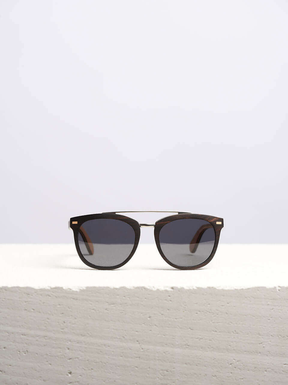 Wooden sunglasses with dark lenses in a neutral background, showcasing a unique and eco-friendly design. Perfect for stylish sun protection.
