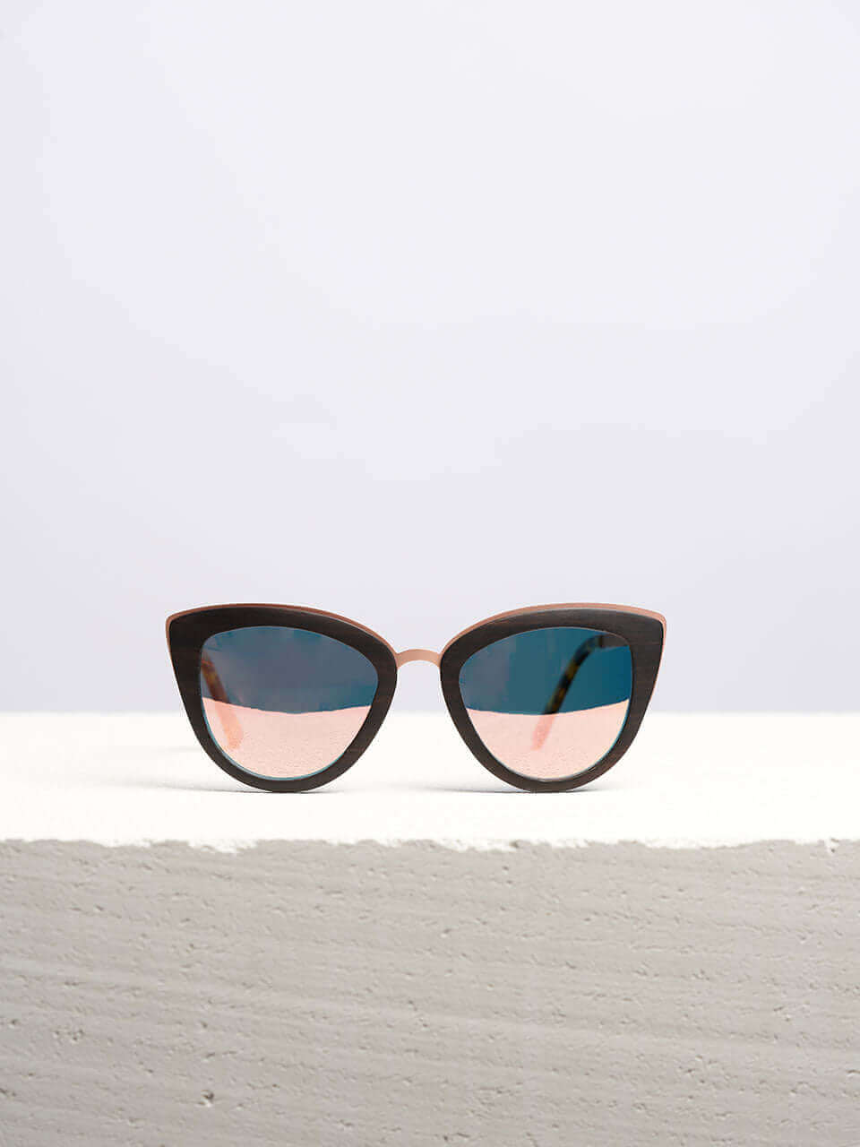 Wooden sunglasses with dark lenses in a neutral background, showcasing a unique and eco-friendly design. Perfect for stylish sun protection.