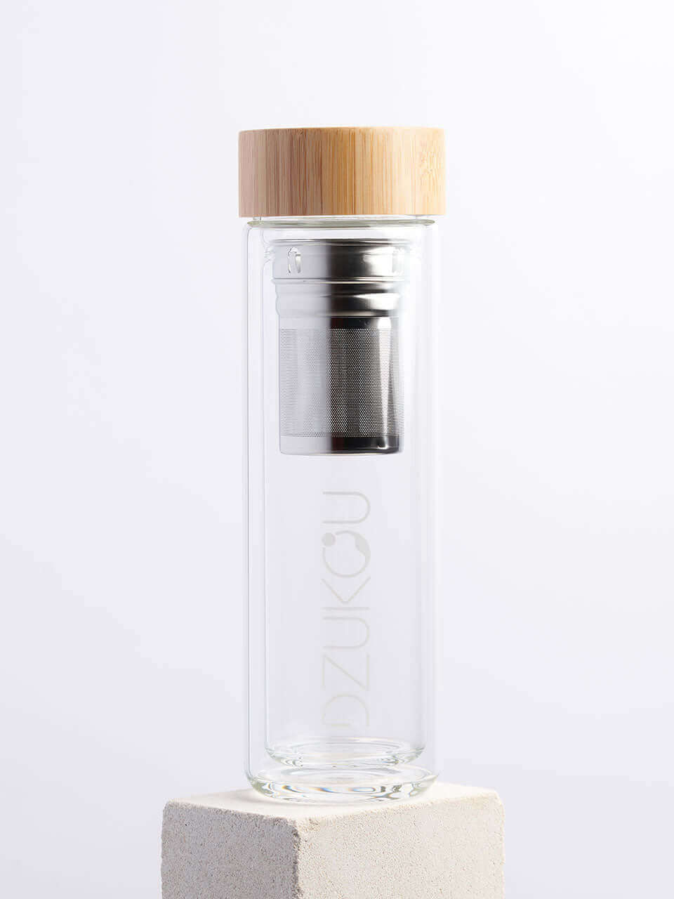 A glass bottle featuring both a bamboo lid and a metal lid in a white background, showcasing a blend of natural and modern materials.